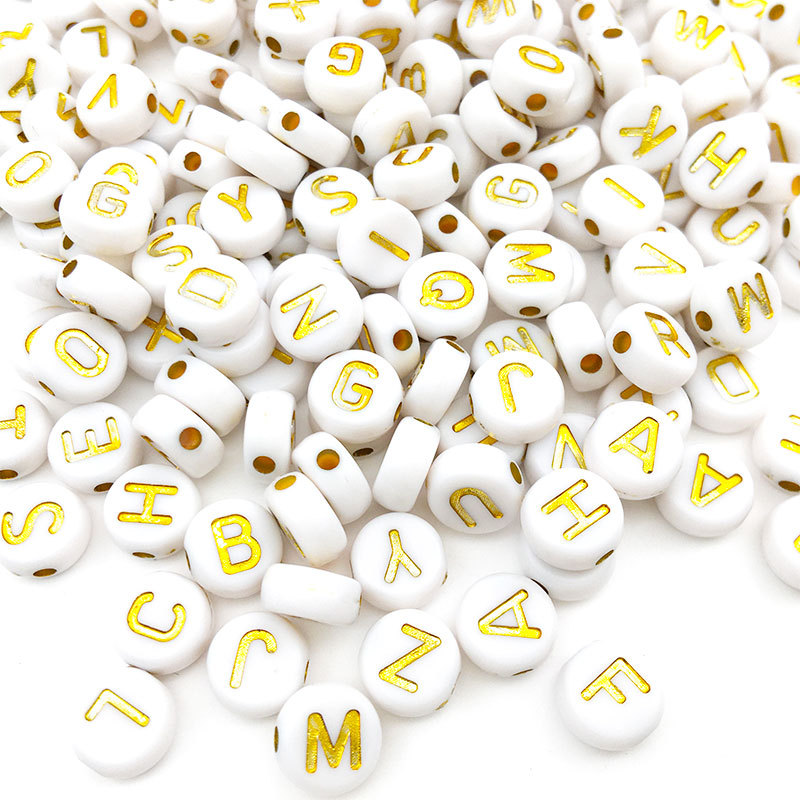 Lettre ronde-or avec des perles blanches