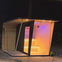 Sauna extérieur moderne en bois de cèdre noir imprimé pour 2 à 6 personnes, avec poêle à vapeur et pierres volcaniques, idéal pour villa ou parc.