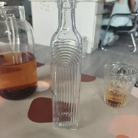 Carafe en verre carrée vintage à rayures verticales côtelées et arquées, idéale pour le stockage d'huile d'olive, de jus et de boissons sur la table de cuisine