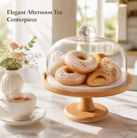 Support à gâteau rond blanc surélevé avec bordure conique en bois, dôme en verre transparent et bouton sphérique pour présentation sur table à manger