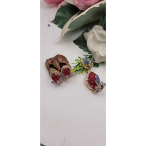 Les boucles d'oreilles sont ornées de pierres rouges sculptées et de pierres bleues serties dans un cadre doré, orné de petites pierres blanches. - Product Image 1