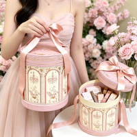 Boîte cadeau cylindrique rose exquise, fabriquée en carton rond luxueux, accompagnée d'un ruban pour la décoration.