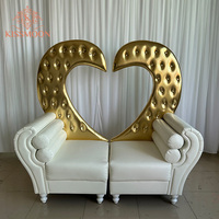 Magnifique chaise double en bois massif en forme de cœur doré avec revêtement en cuir blanc capitonné pour les événements de mariage et les banquets