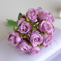 Un ramo de rosas simuladas de 12 cabezas hecho a medida. Una novia falsa de boda sostiene 12 rosas de seda entre sus manos.