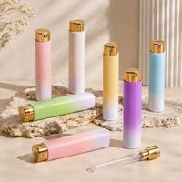 Lot de 100 flacons vaporisateurs de parfum de voyage cylindriques de 10 ml, avec coque en plastique, insert en verre et pulvérisateur doré à ouverture par torsion