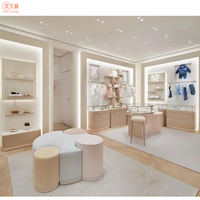 Magasin de vêtements pour bébés crème Aménagement d'intérieur Présentoirs pour magasin de vêtements sur mesure Vente directe
