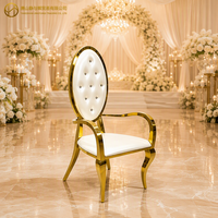 Chaise de mariage de luxe élégante en acier inoxydable doré avec dossier ovale capitonné en cristal et accoudoirs, idéale pour la location événementielle