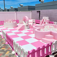 Ensemble d'équipements de jeux gonflables pastel rose avec château gonflable, piscine à balles fleurie et manège pour enfants, idéal pour la location de fêtes d'anniversaire