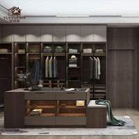 Grande dressing moderne ouverte avec finition en bois naturel et tiroirs à fermeture amortie