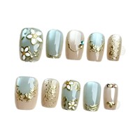 Ongles bleu brumeux à motif géométrique animalier, style français court, fleurs dorées, texture luxueuse haut de gamme