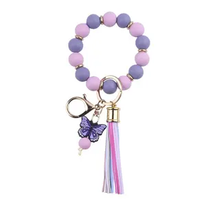 Bracelet porte-clés en perles de silicone avec papillon et pompon en cuir pour femmes/filles