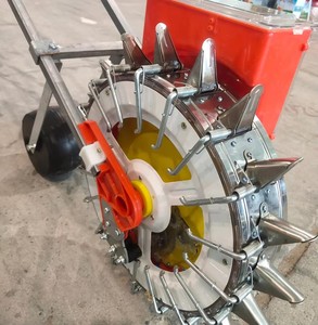 Semoir manuel pour graines d'oignons avec trémie rouge et roue à pointes jaunes pour un semis de précision dans les jardins potagers - Product Image 2