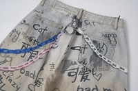 Jean baggy unisexe beige gris délavé avec imprimé graffiti intégral, coupe large, avec breloques en peluche et détails de chaînes colorées
