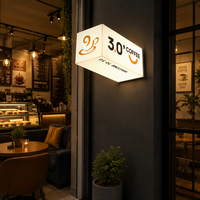 Enseigne lumineuse LED pour café, trois faces, montage en coin, éclairage blanc, texte noir, logo orange pour vitrine de café, signalétique commerciale