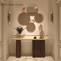 Console d'entrée design avec structure en bois massif, base à panneaux texturés et plateau en marbre pour intérieurs de luxe