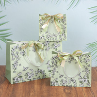 Collection de sacs cadeaux botaniques sophistiqués A1 avec motifs floraux et oiseaux, nœuds en satin superposés, poignées tressées et ensemble de tailles
