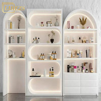 Étagère de présentation moderne blanche pour produits de beauté, aménagement de magasin de soins de la peau, éclairage LED, rangement arqué, boutique commerciale, salon de beauté haut de gamme