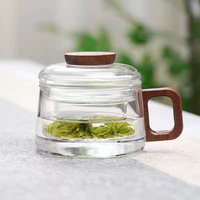 Tasse à thé en verre gris fumé avec poignée en bois et infuseur à couvercle pour la préparation du thé à la maison ou au bureau