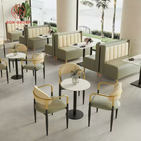 Ensemble de mobilier de restaurant commercial, cadre beige, canapé en cuir vert, banquette avec table carrée en marbre et pieds en métal pour café