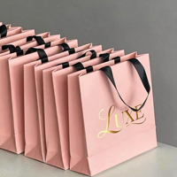 Sac en papier texturé noir gaufré de luxe 2026 avec logo personnalisé et poignée en ruban gros-grain pour emballage cadeau