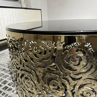 Table basse de luxe moderne de style moyen-oriental avec base en acier inoxydable, motif rose en métal robuste fait main et plateau en verre trempé