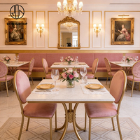 Elegante Franse roze fluwelen bankzittingen met gouden frame, tafel en stoelen van gesinterd steen, meubelset voor koffieshop en restaurant