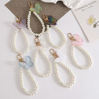 En gros, Porte-clés élégant papillon imitation perle, Chaîne de téléphone papillon en résine tendance, Bracelet de poignet à perles, Breloque de sac pour femmes