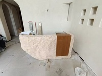 Comptoir d'accueil aspect pierre naturelle, style Wabi-sabi moderne avec texture de roche irrégulière pour spa et salon haut de gamme