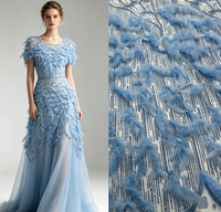 Tissu en dentelle brodée à la main, orné de plumes et de paillettes, idéal pour robes de soirée de luxe et la couture.