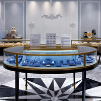 Vitrine à bijoux ovale en acier inoxydable PVD or avec verre incurvé, éclairage LED, design écologique et étanche pour centres commerciaux