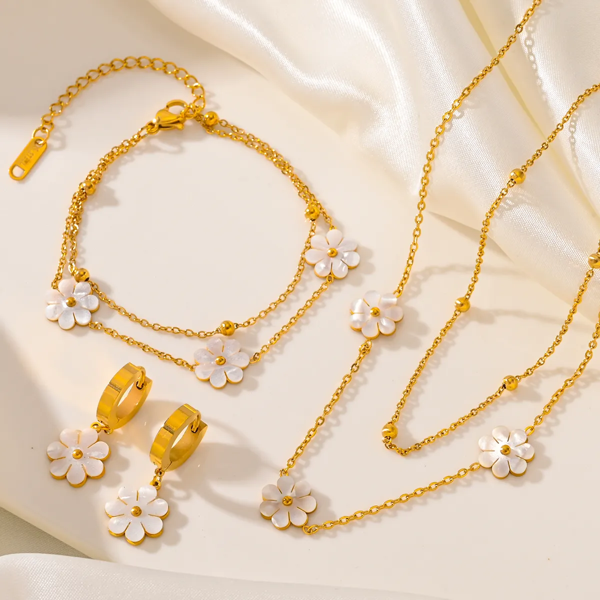 Venta caliente pequeña Margarita conjunto de joyería de acero de titanio para mujer Pendientes chapados en oro collar tobillera con diseño de moda