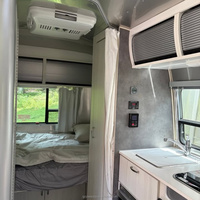 Caravane mobile entièrement équipée, style rétro, en aluminium argenté, pour la location en resort.