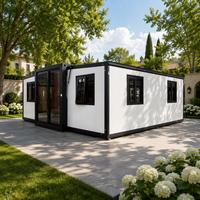 Villa de luxe moderne en conteneur extensible de 20 pieds, à double ailes, avec cadre noir et panneaux muraux blancs, deux chambres et un appartement