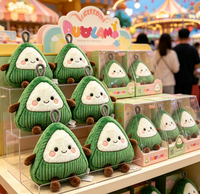 Peluche Zongzi en forme de ravioli de riz, enveloppée d'un tissu en velours côtelé vert triangulaire, avec visage souriant et membres marron, à suspendre