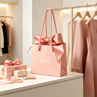 Sac en papier cadeau de luxe rose personnalisé avec logo et nœud en soie, idéal pour l'emballage de vêtements et de parfums, parfait pour les cadeaux de mariage et d'anniversaire.