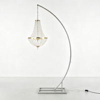 Lustre suspendu moderne et élégant en cristal, support doré incurvé pour mariage, idéal pour réceptions intérieures et allées.