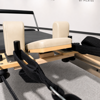 Reformer Pilates Kayu Maple Solid Warna Krem dengan Rel Tetap untuk Dekompresi Tulang Belakang, Keseimbangan, dan Ruangan Studio yang Terang