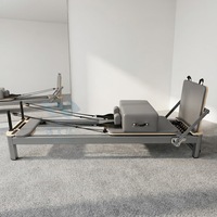 Reformer de Pilates commercial en aluminium avec cadre métallique gris mat, pour usage en studio, avec ressorts de qualité