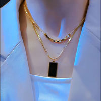 Collier à deux niveaux avec petites perles carrées dorées et chaîne serpent rectangulaire noire