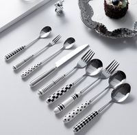Ensemble de couverts en acier inoxydable à motif blanc et noir, avec poignées en céramique, pour une table de cuisine lumineuse et coordonnée