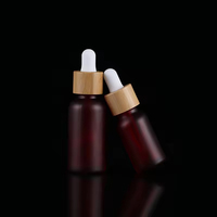 Botol Tetes Kaca Merah Buram dengan Logo Kustom Profesional dan Tutup Bambu untuk Penyimpanan Minyak Esensial Kosmetik Merek Kecantikan.