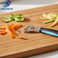 Ecologisch verantwoorde keukenhulp van roestvrij staal: fruit- en groenteschiller (driehoekig, voor wortels en aardappelen) met rubberen handvat, voor huishoudelijk gebruik.