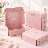 Boîte d'expédition en carton rose poudré pour emballage de produits de beauté, d'ambiance et de parfums, avec logo de marque et inscriptions