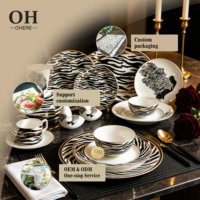 Service de table de luxe en porcelaine fine, décor artistique, avec bols, tasses et soucoupes, idéal pour événements, traiteur et location