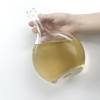 Bouteille à liqueur ronde en verre à base épaisse et col long