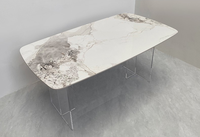 Table à manger moderne en pierre frittée à motif Calacatta avec piétement incurvé en acier inoxydable 316
