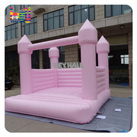 Château gonflable rose pâle macaron pour enfants et adultes, idéal pour la location lors de mariages et fêtes