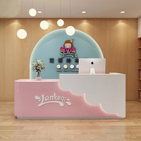 XTQT-052 Modern Ofis Resepsiyon Masası Küçük Pembe Lüks Melamin Levha Tam Kenar Kaplama Dayanıklı Yüksek Maliyet Performanslı Otel İçin