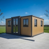Vente en gros de maison préfabriquée extensible avec cadre gris et finition bois clair, étanche et isolée, pour une utilisation en extérieur dans tous les climats
