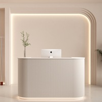 Comptoir de réception de salon de beauté incurvé en MDF blanc avec logo gravé personnalisé rétroéclairé par LED